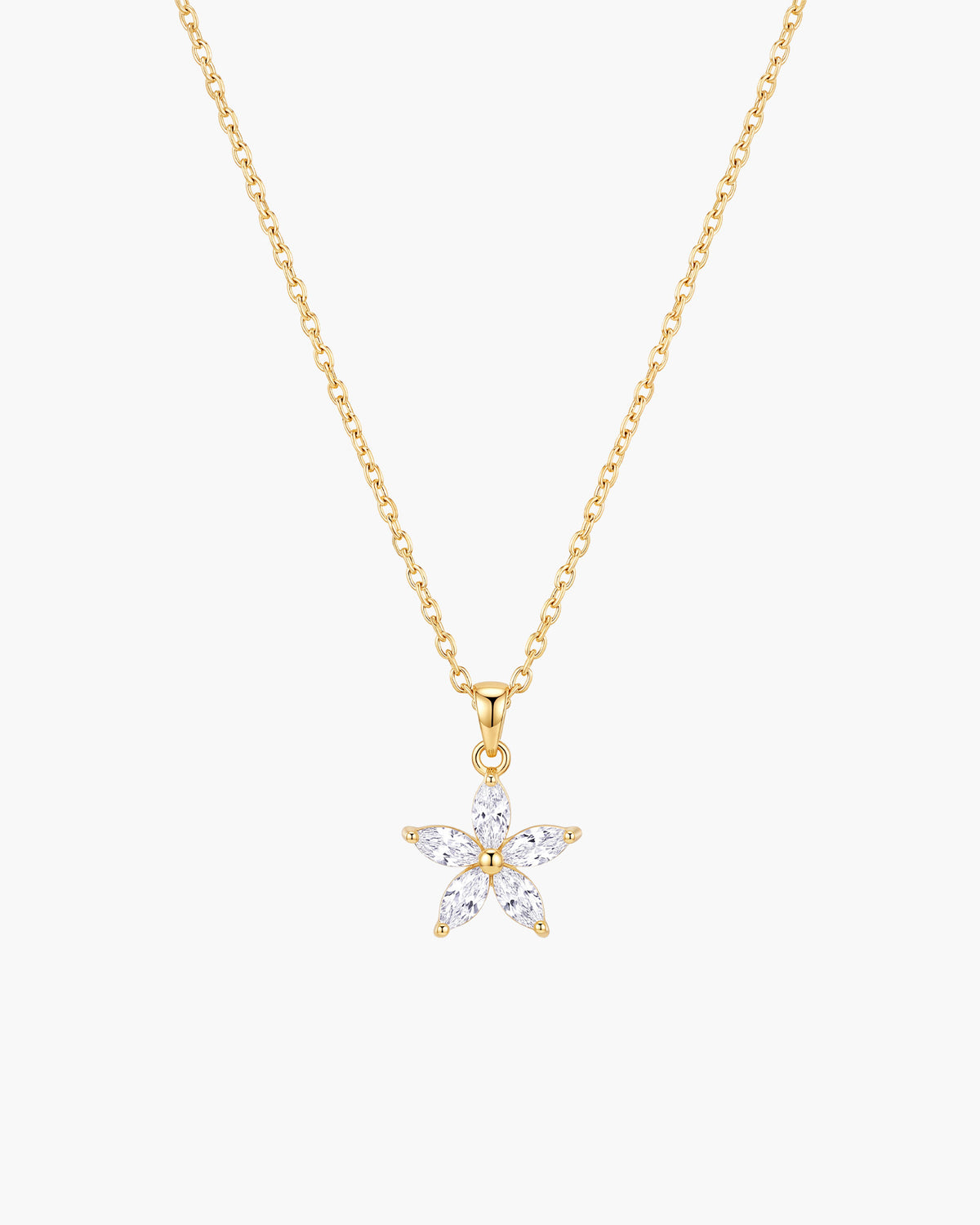 Collar Fleur, colgante de flor de cinco pétalos con piedras transparentes en talla marquesa en cadena de eslabones en tono dorado, sobre fondo blanco