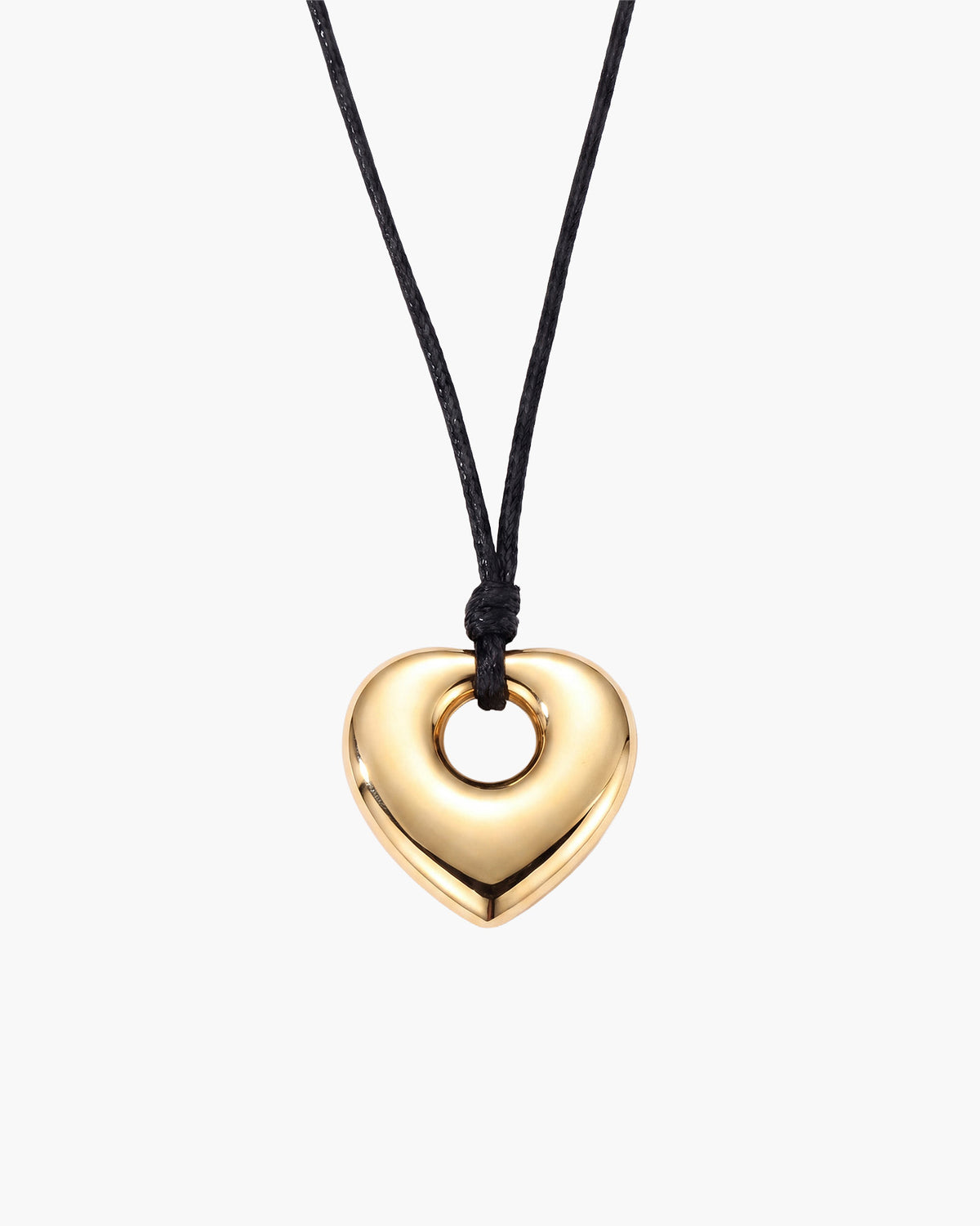 Collar Amara, colgante pulido de corazón abombado en tono dorado con el centro abierto en cordón negro encerado, sobre fondo blanco