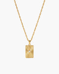 Collar Celeste, colgante rectangular en tono dorado con relieve de rayos de sol y una piedra transparente en el centro
