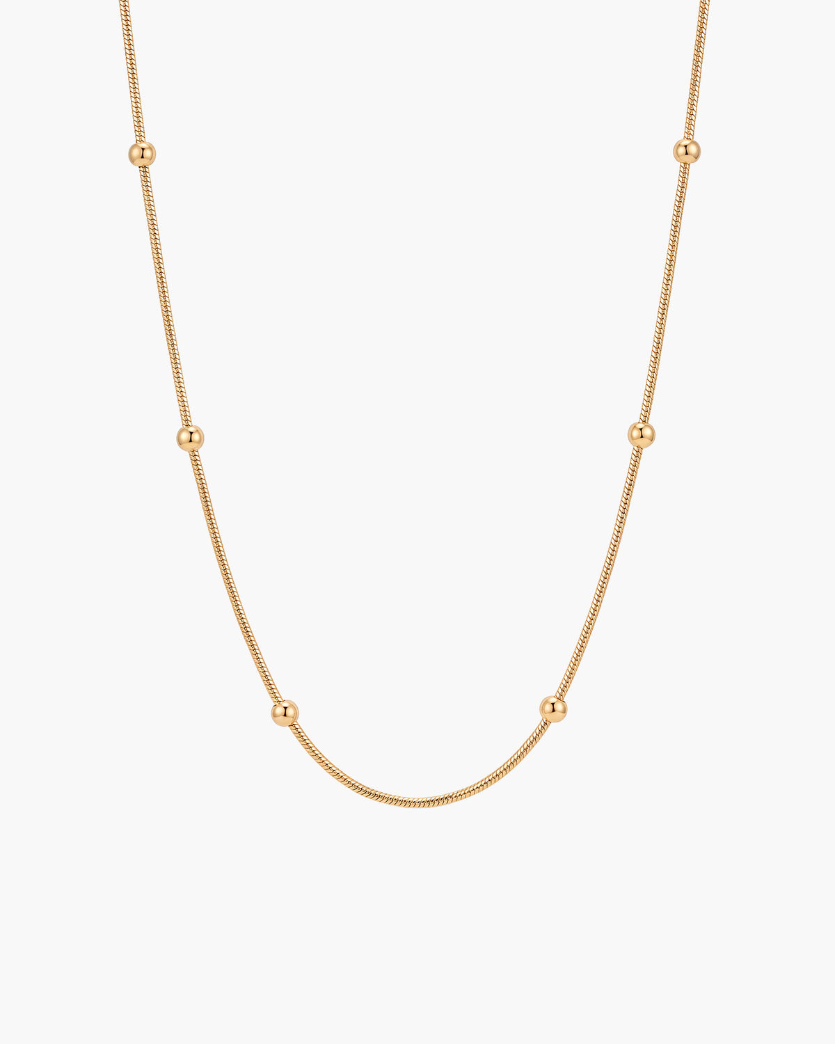 Collar Bella, cadena snake fina en tono dorado con cuentas doradas pulidas a intervalos regulares, sobre fondo blanco